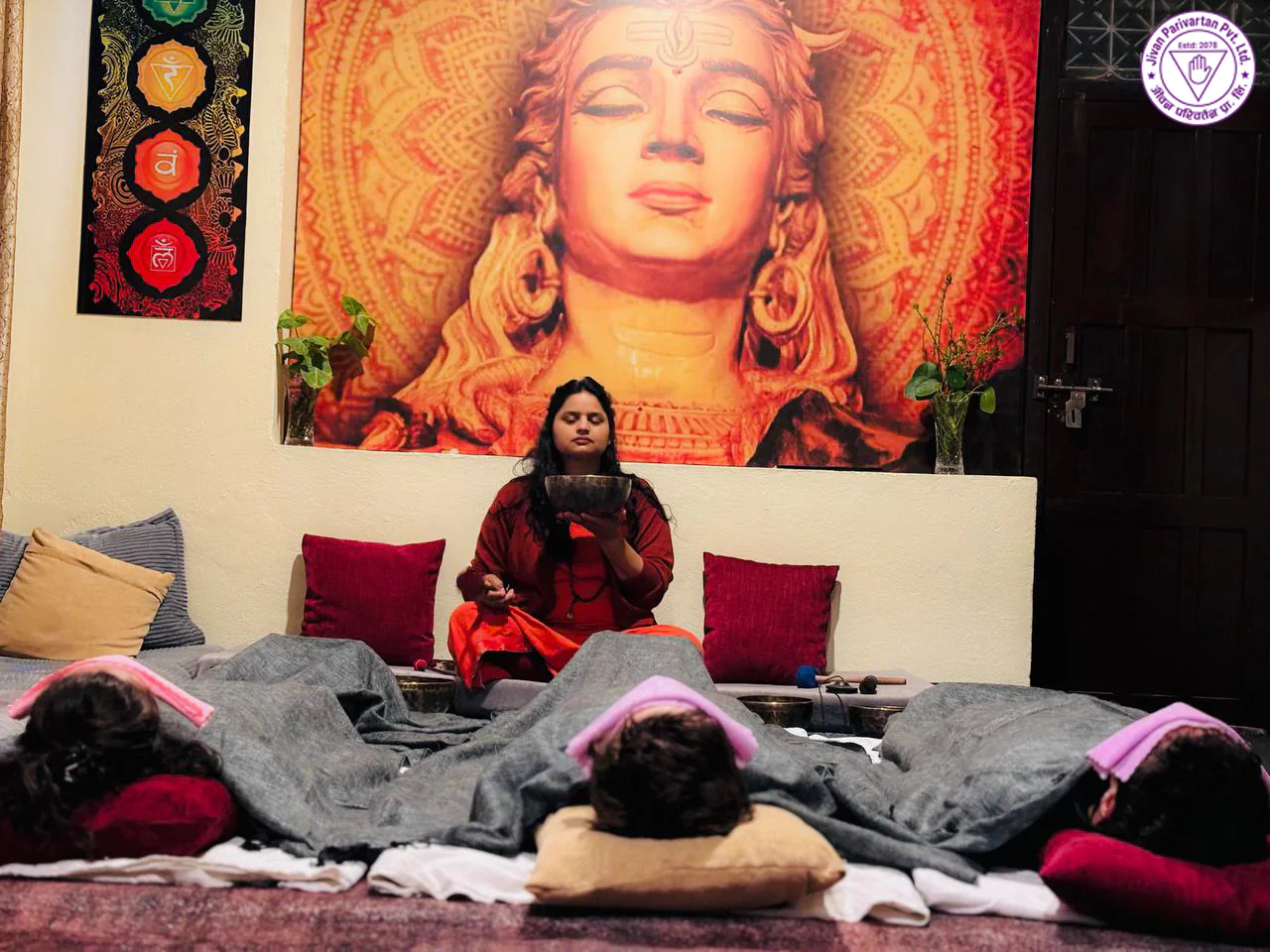 Singing bowl sound healing session at Jivan Parivartan, guests resting under blankets